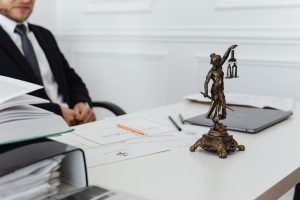 A legal professional's workspace featuring Lady Justice statue, documents, and a laptop.
